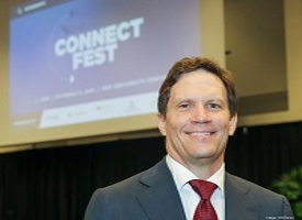 Photo of William Klostermeyer standing in front of presentation Connect Fest slide 