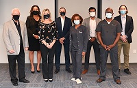 3 women and 5 men wearing masks and business attire