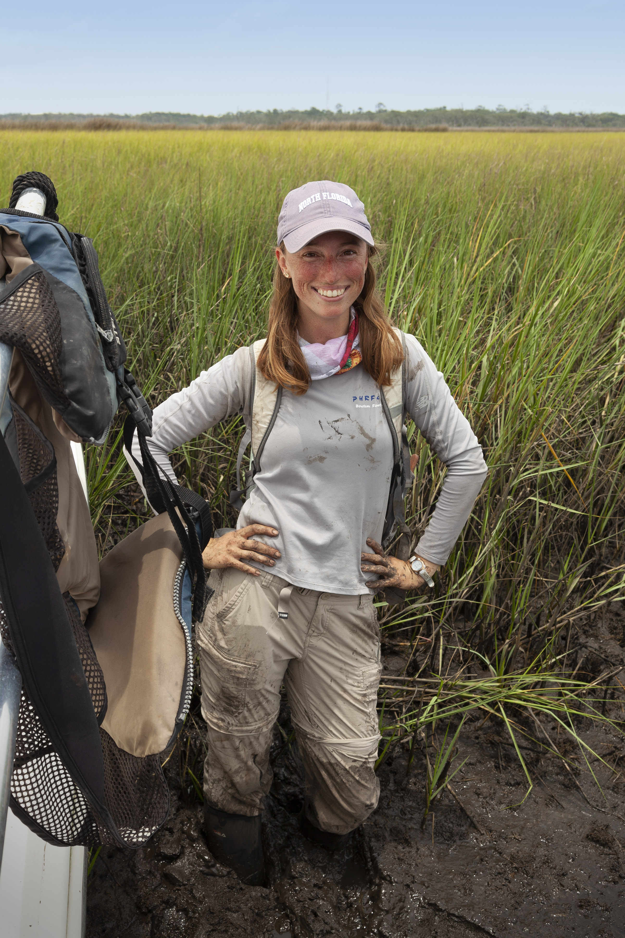 Undergraduate Research of the Month Shannon Brew posing in a marsh in front of tall grass