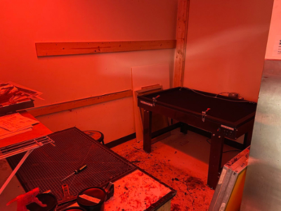 dark room with red light and tables to develop photography