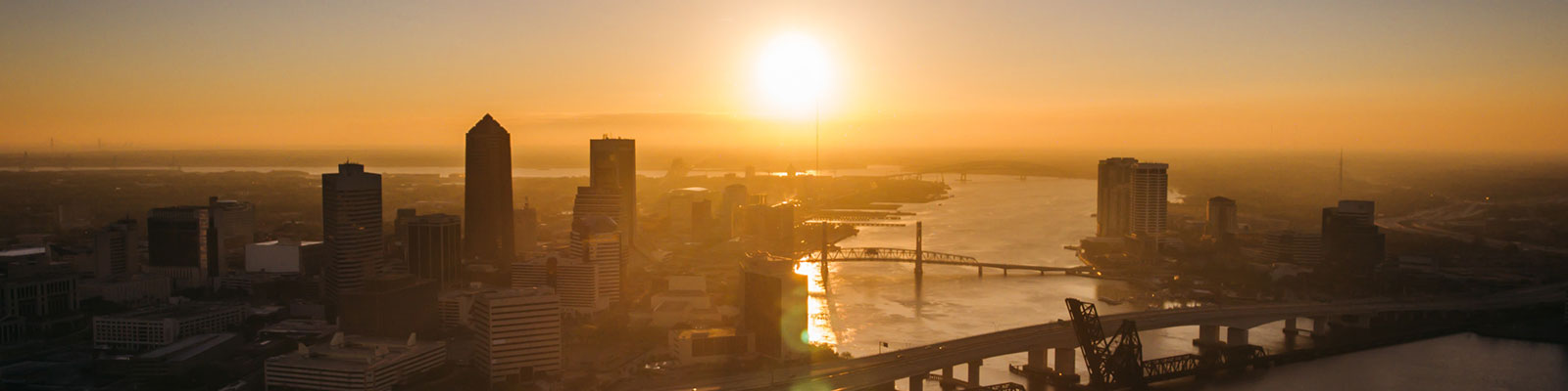 aerial scene of jacksonville city with its bridges and a sunset in the backdrop