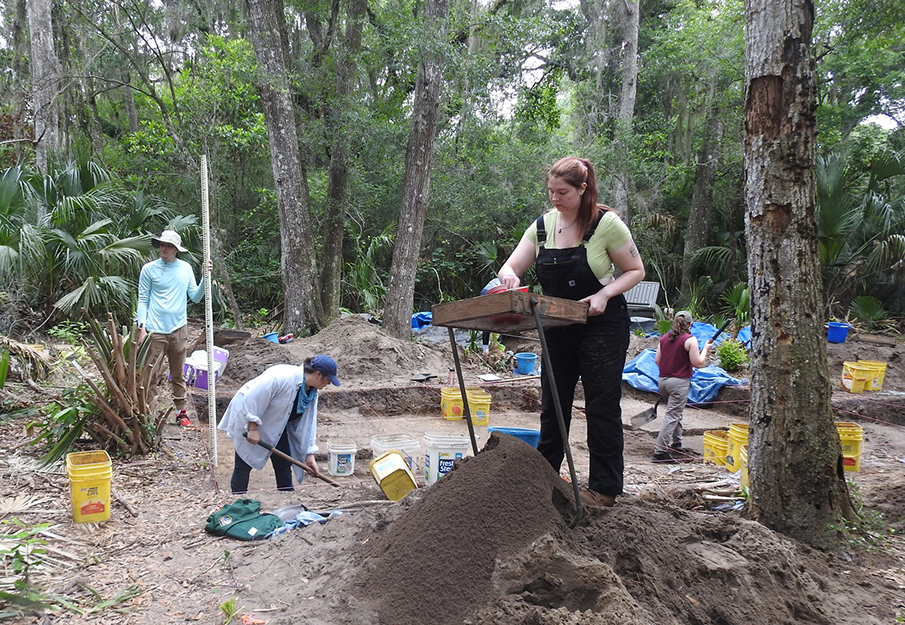 Different members of the Archeology Lab working at the archeology site, digging and sifting through the dirt