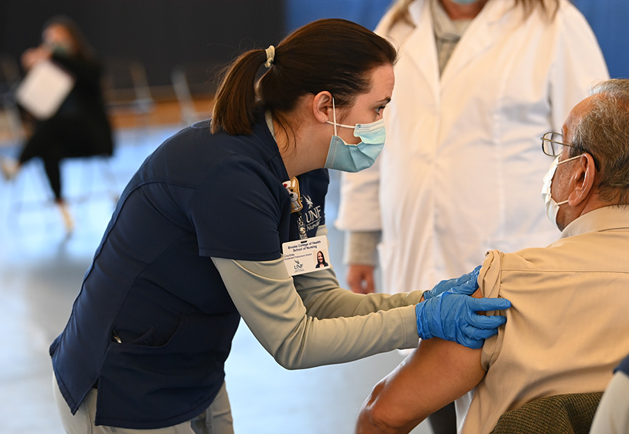 UNF nurse distributing a COVID-vaccination