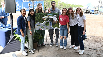 Student leaders posing near the UNF final rendering at the groundbreaking event