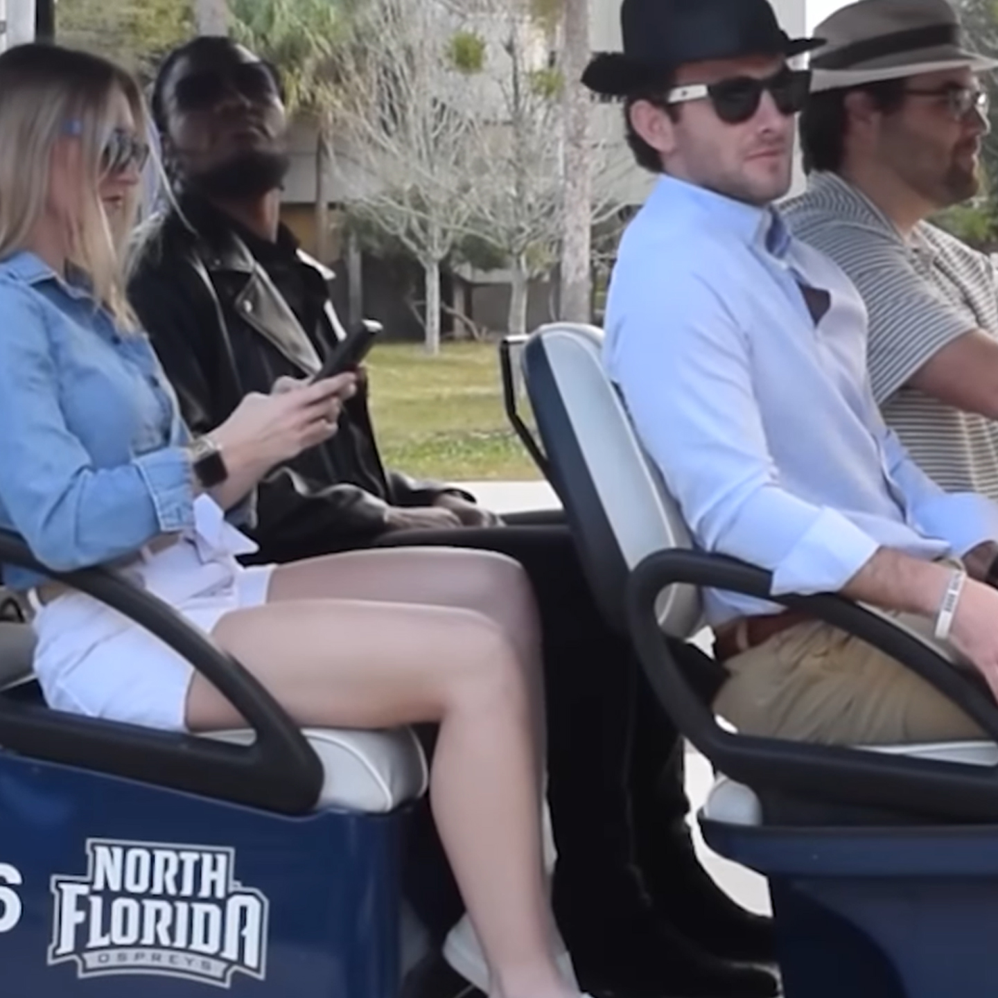 a group of people driving around in a golf cart