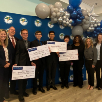 Student team with judges in front of balloon backdrop