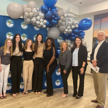 Team photo of students in front of balloon backdrop