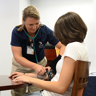 nursing student taking a woman's blood pressure
