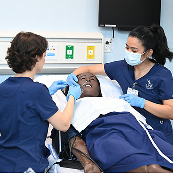 Two nursing students working in the Simulation Lab
