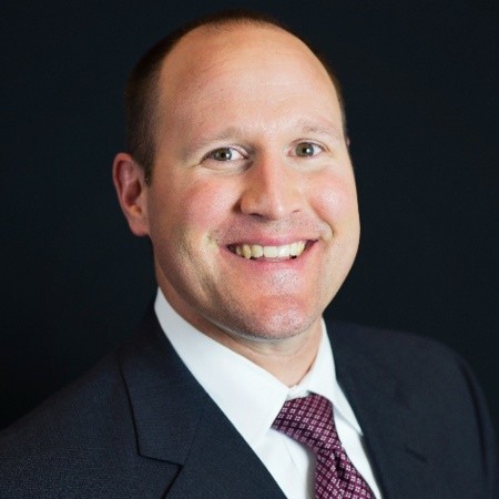 Bald white male white shirt red tie black suit black background
