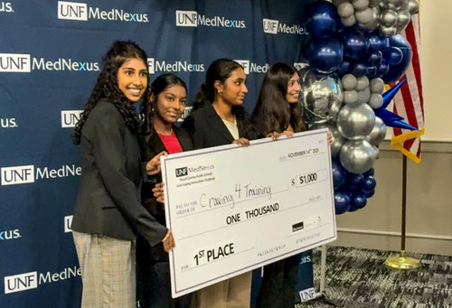 Four high school girls holding big check 