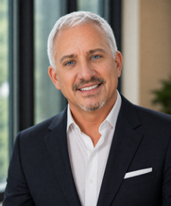 White male with blue eyes black suit jacket and white shirt