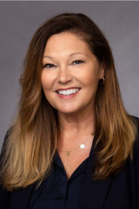 Shana Zink Headshot woman black blazer light brown hair smiling