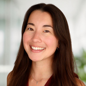 Asian girl with brown hair and eyes smiling into camera