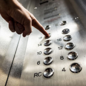 Hand pushing button on elevator