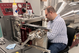 Man sitting at desk with silver machinery