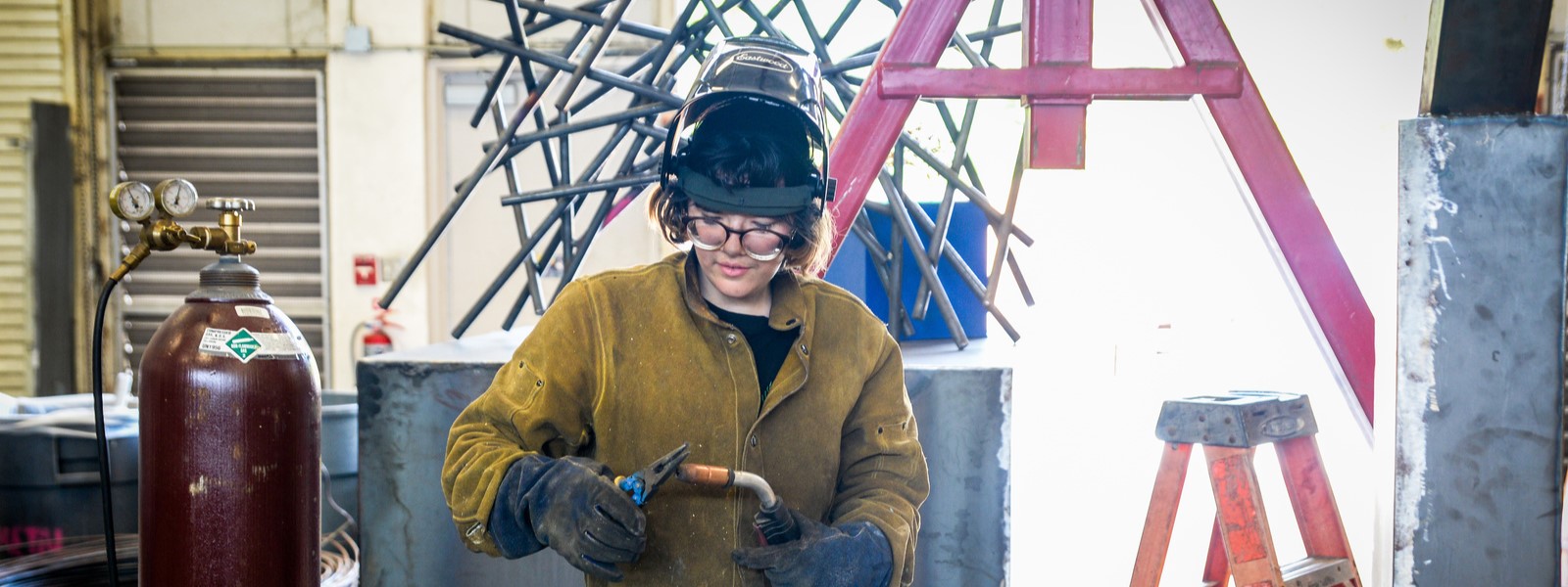 student welding a sculpture
