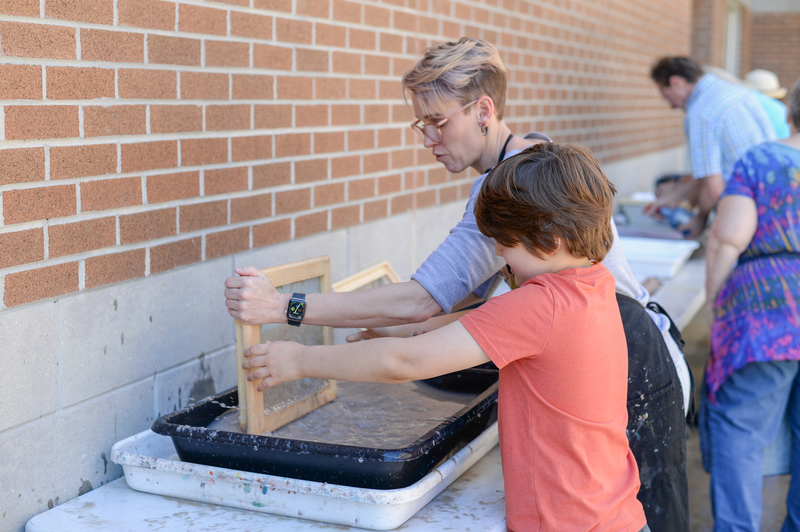 Teacher assisting student with screen printing