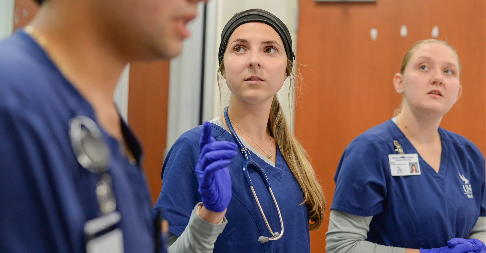 nursing student looking at and listening to an instructor