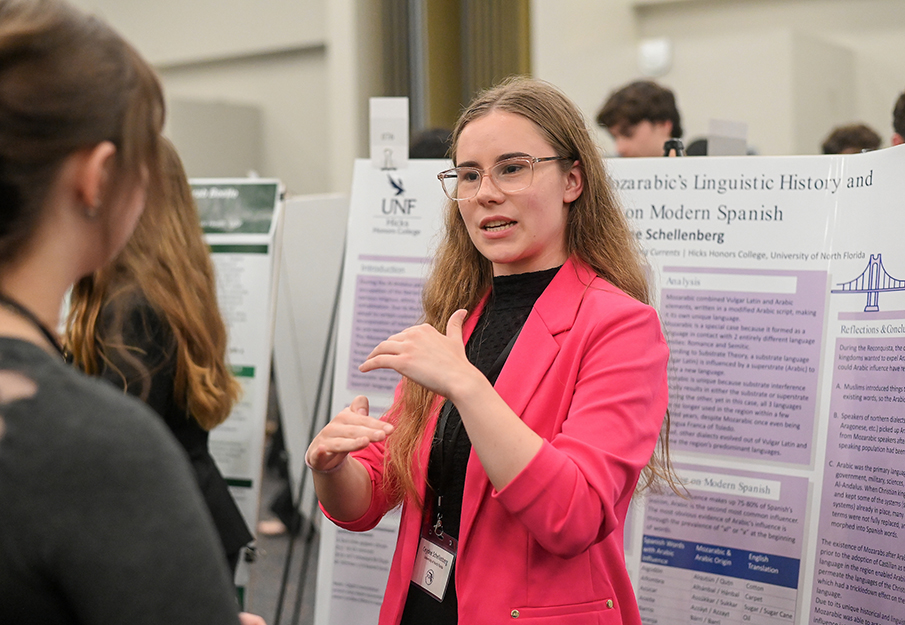 Student in pink jacket presenting poster