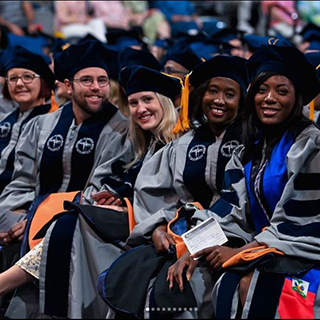 Spring 2022 graduates smiling at commencement