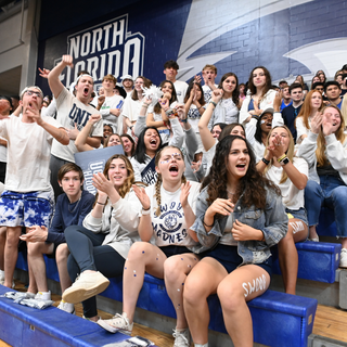 Students in student section cheer for UNF basketball game. 