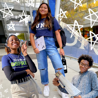 Three students wearing UNF apparel smiling. White stars surround students. 