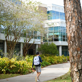 Student walking in front of building on campus