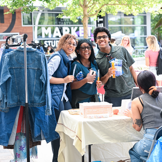 three students stand and smile at market days