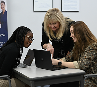 two students learning from a professor