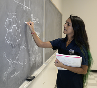 a student writing on a chalkboard