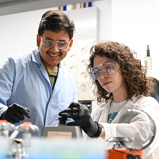 students working in a lab looking at an instrument