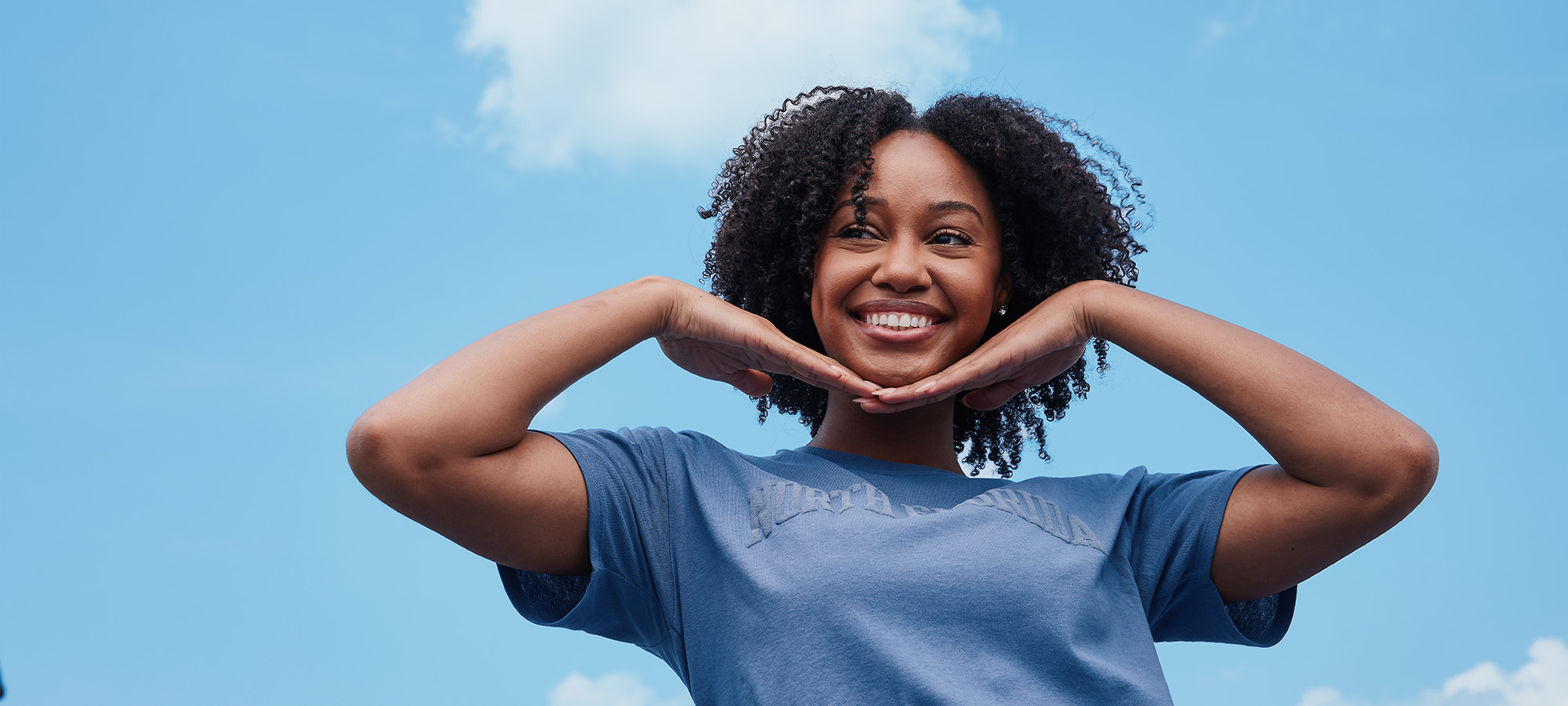 Girl smiling with her hands underneath her face