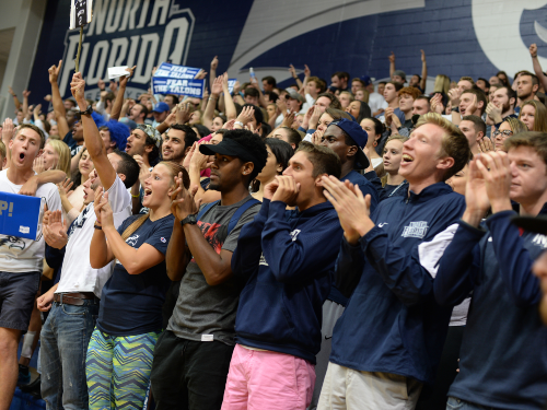 Group of students at a basketball game cheering on the team