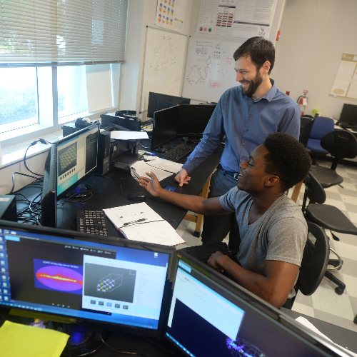 instructor and student looking at a computer screen