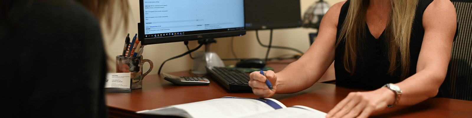 Advisor marking something with a pen in a brochure