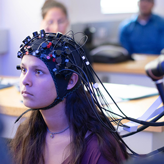 Female student wears neural-monitoring device on her head