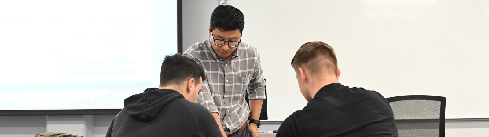 A teacher talking to two students