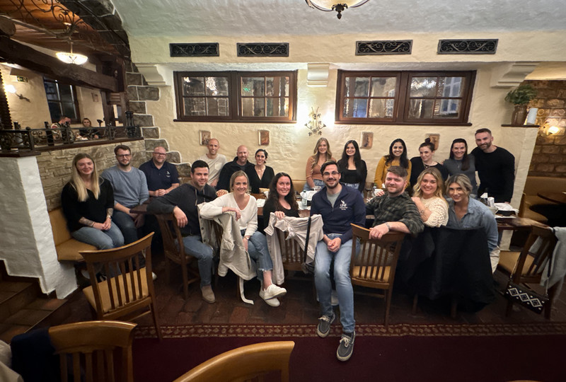 people sitting around a table and posing for a picture at a cafe