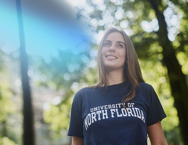 student looking up with a cyan and navy gradient on the top corner