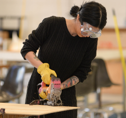 Female using a table saw in a workshop