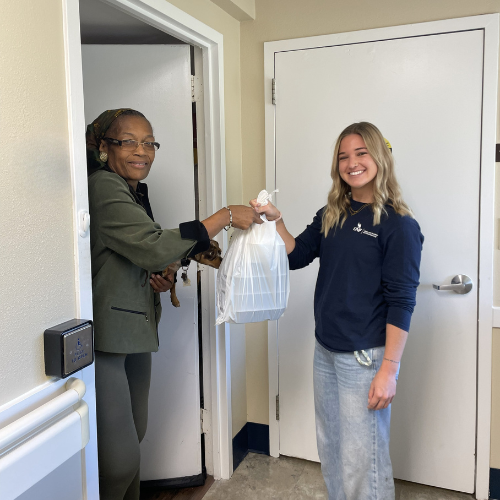 Kayla delivery a meal to a senior at Sundale