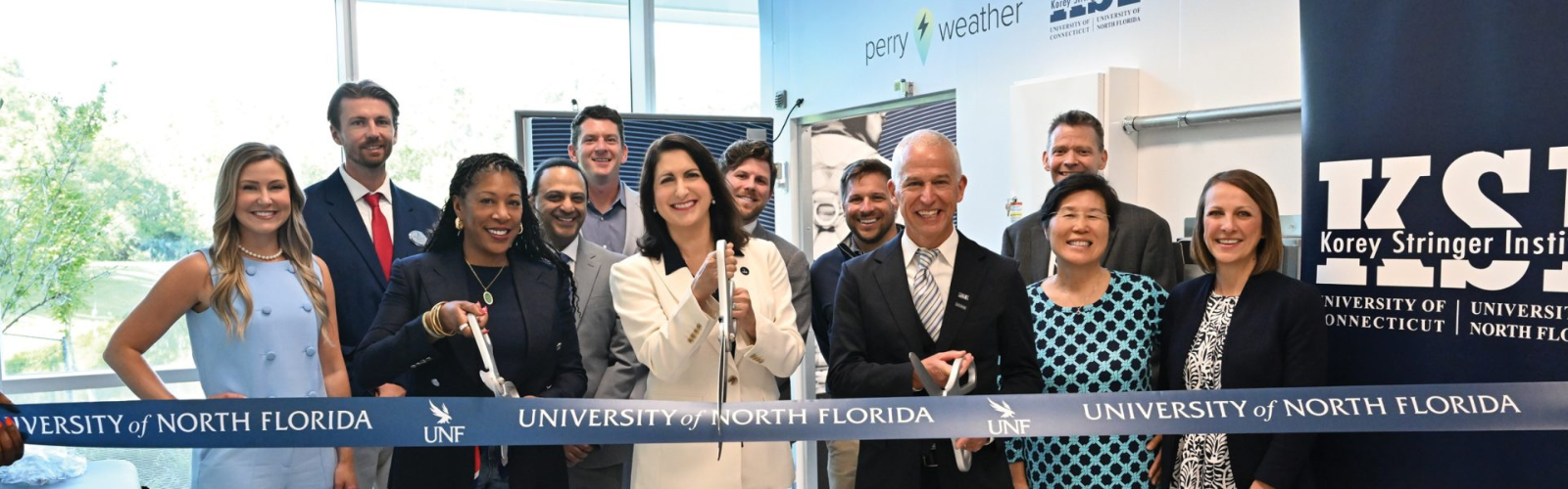 KSI and UNF faculty and staff performing a ribbon cutting