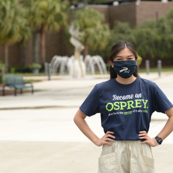 Student standing infront of osprey fountain