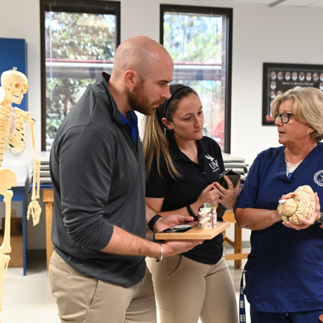 PT Faculty with student holding a human brain