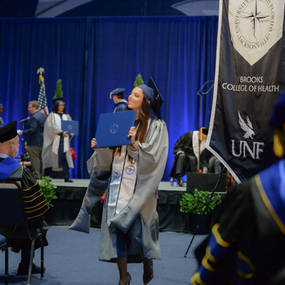 bch student standing with diploma