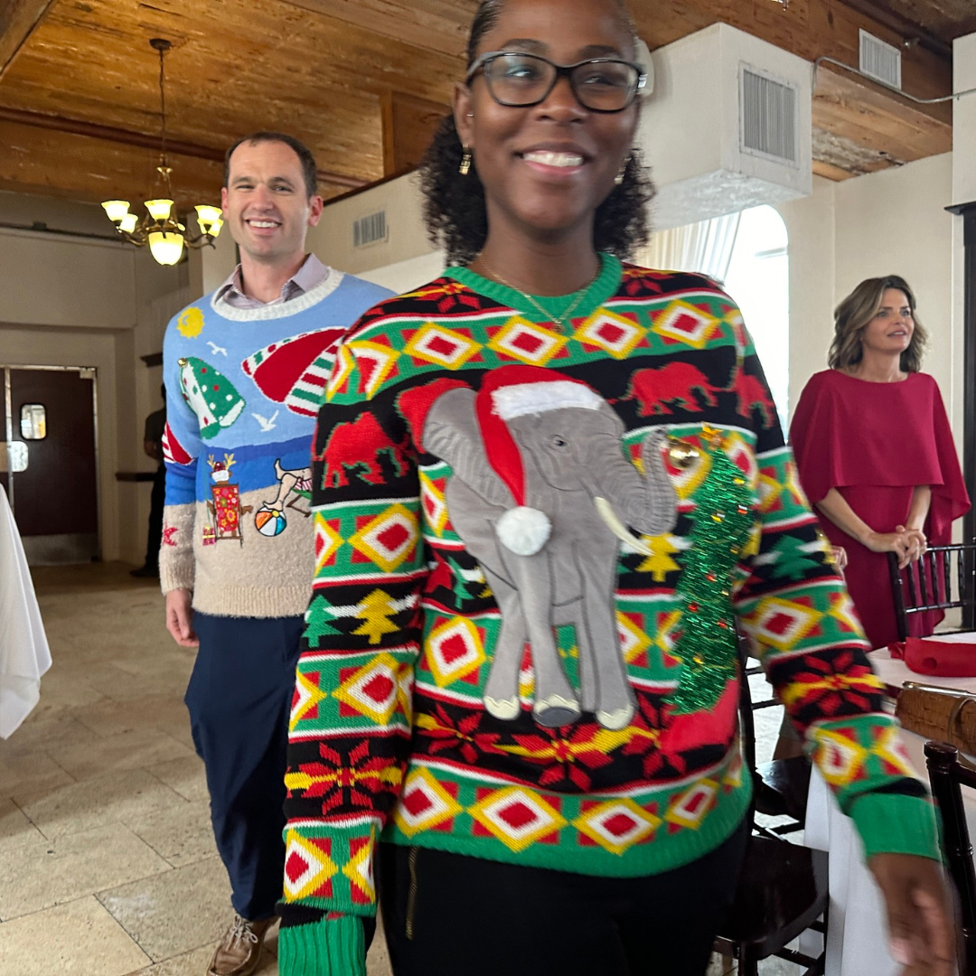 Faculty wearing a elephant ugly christmas sweater for a contest