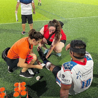 UNF MSAT Alum taking care of an athlete on a sports field