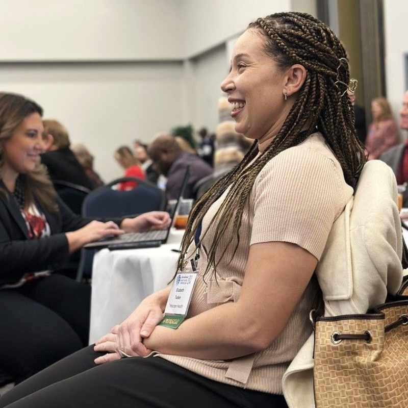 IHS Female Attendee sitting and smiling