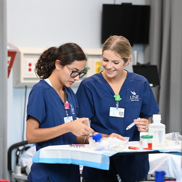 Two nursing students practicing piping technique